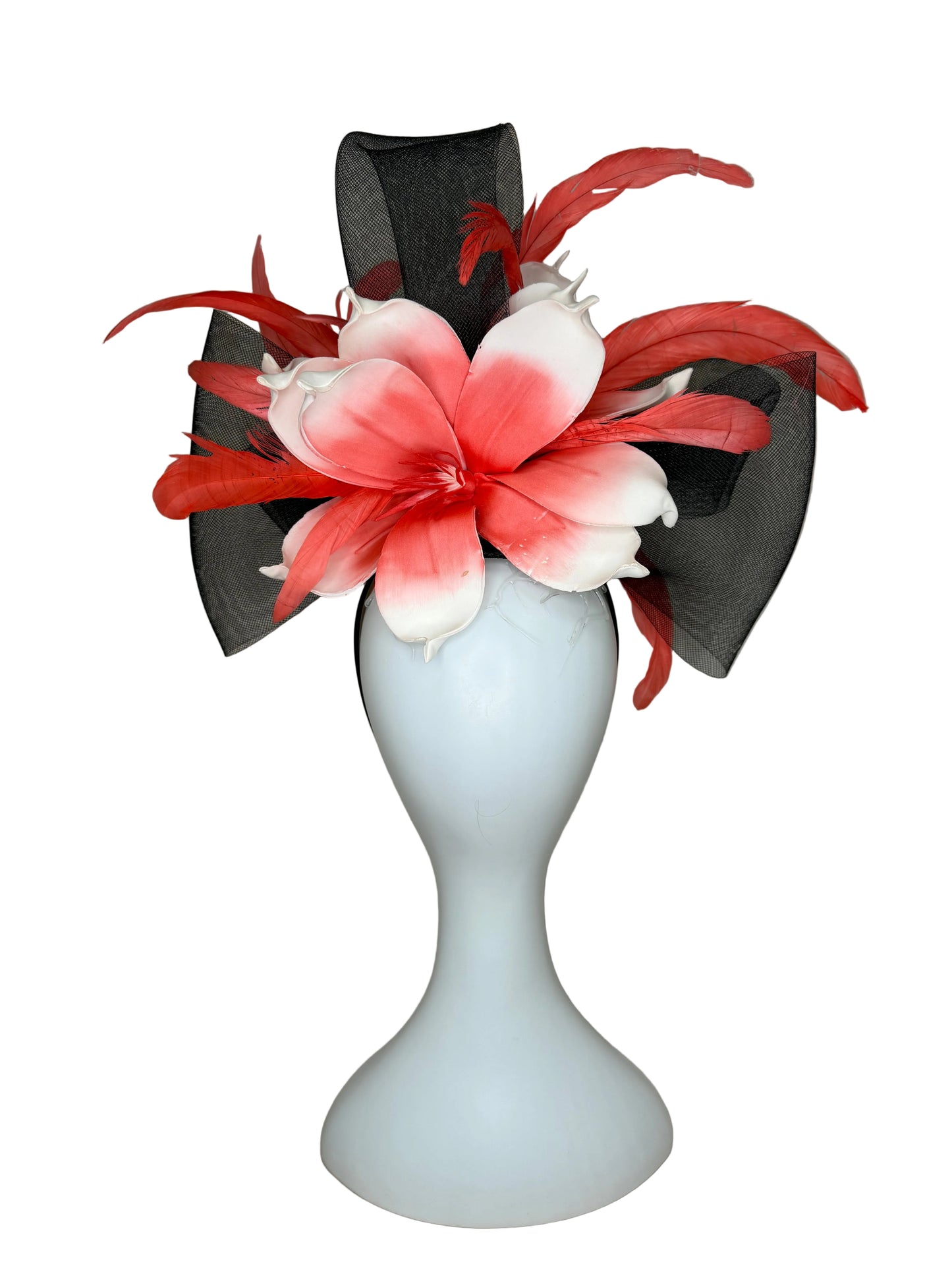 Black hat with pink and white floral decorations on a mannequin head against a plain background