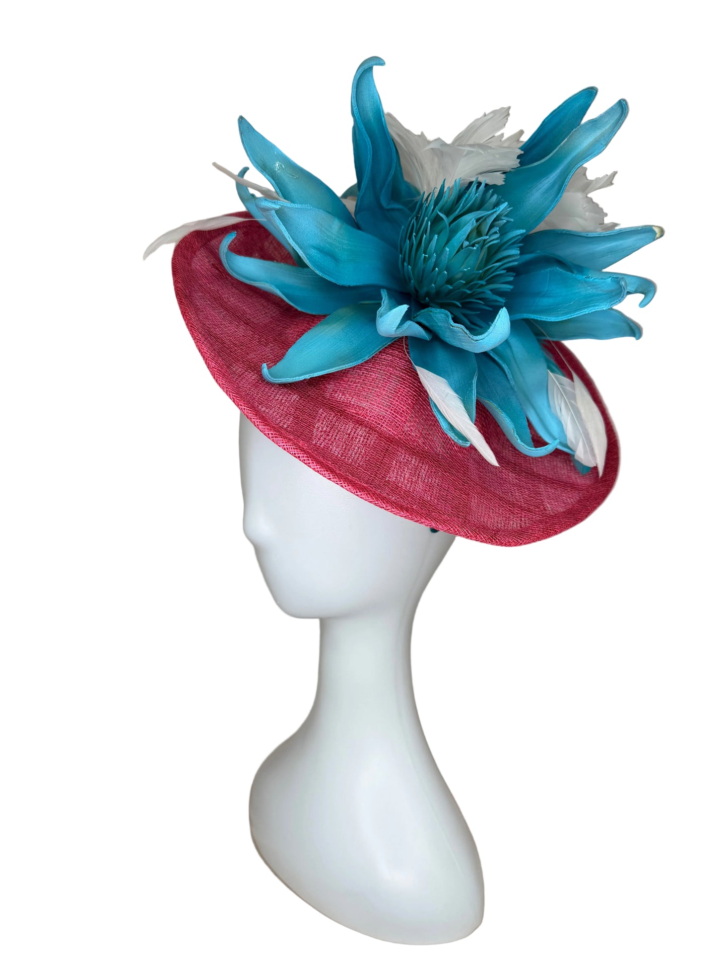 Red hat with blue floral decoration on a mannequin head against a beige background