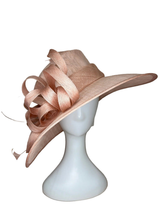 Pink decorative hat on a mannequin head against a beige background