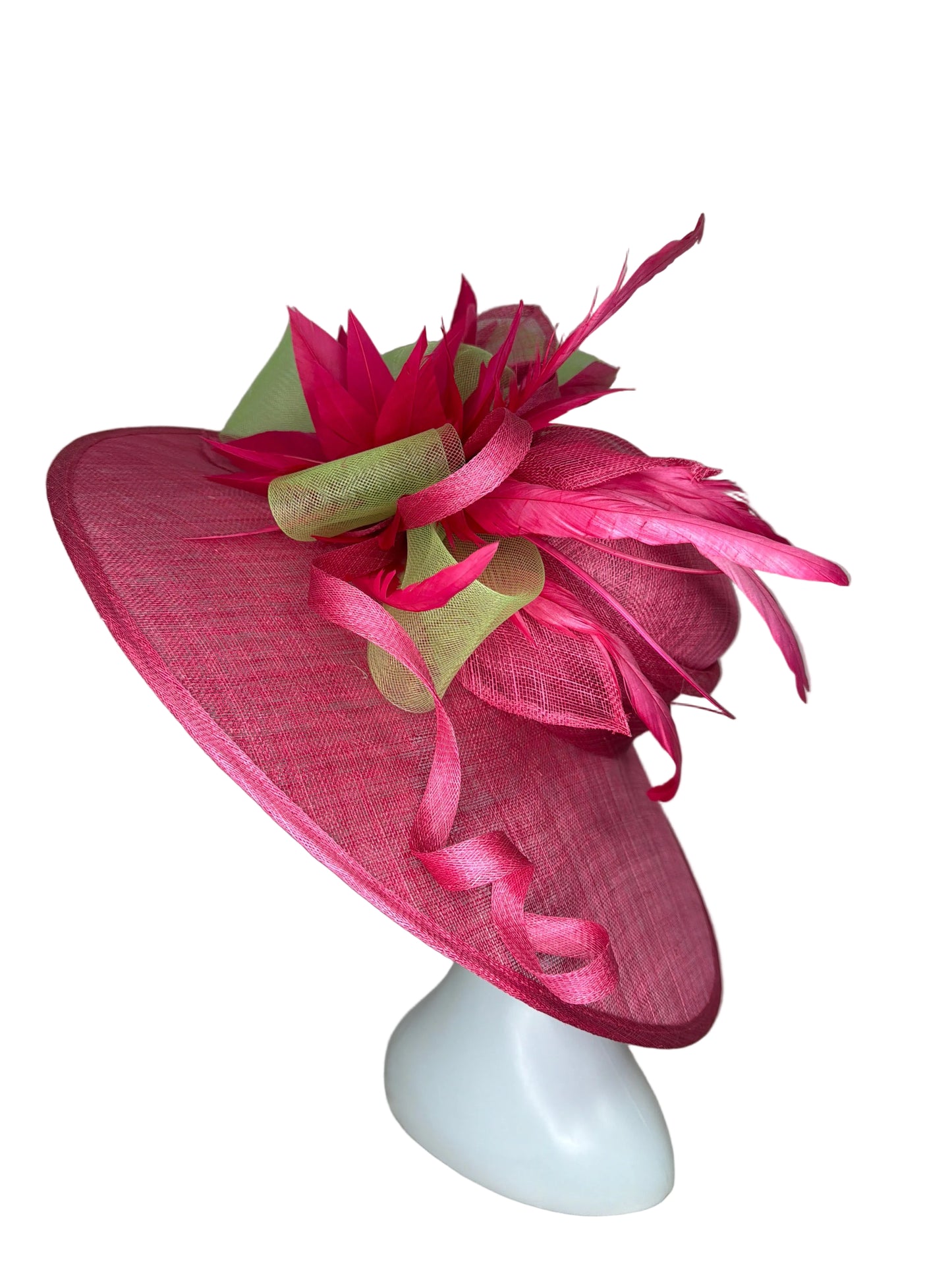 Pink decorative hat with feathers and ribbons on a neutral background