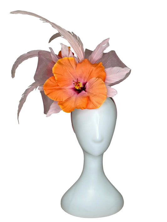 White vase with an orange flower on a beige fabric background