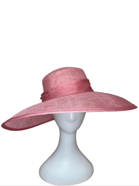Pink wide-brimmed hat on a mannequin head against a beige background