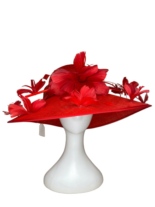 Red decorative hat with floral details on a mannequin head against a beige background