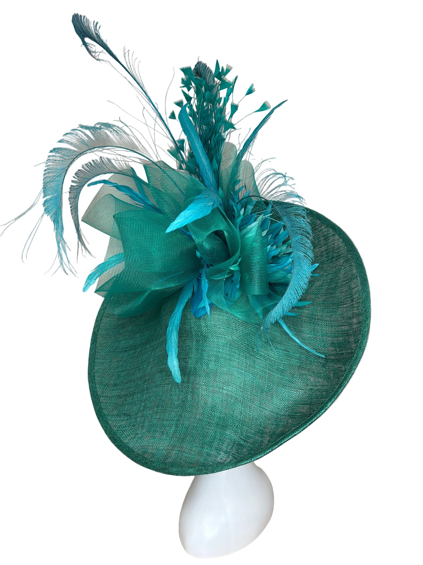 Teal decorative hat with feathers on a beige background