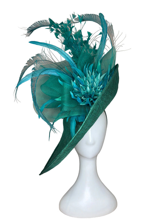 Teal feathered headpiece on a mannequin head against a beige background