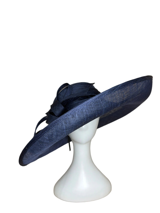 Navy blue hat with feather details on a white mannequin head against a beige background