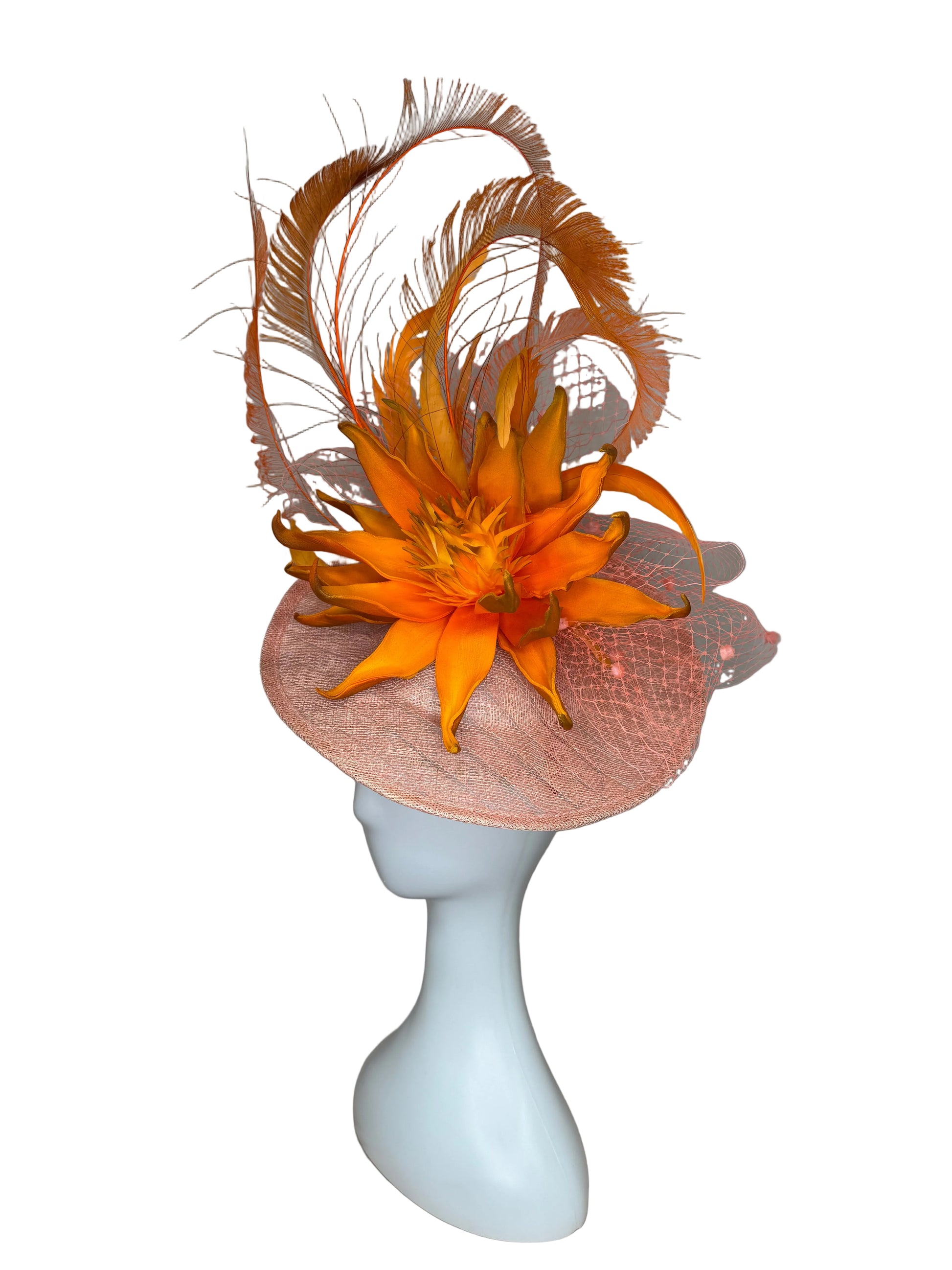 Orange feathered headpiece on a mannequin head against a plain background