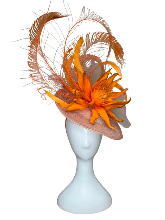 Orange feathered headpiece on a white mannequin head against a beige background