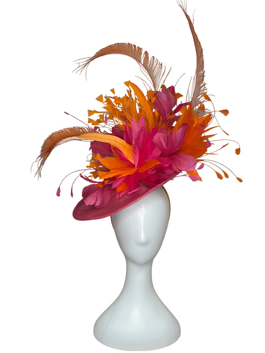 Decorative headband with pink and orange feathers on a beige background