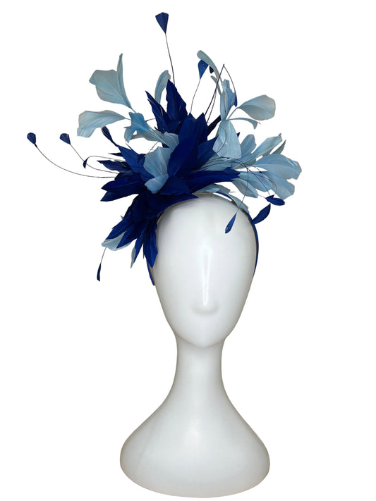 Blue and white feathered headpiece on a mannequin head against a beige background