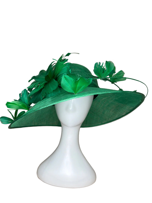 Green decorative hat on a mannequin head against a beige background