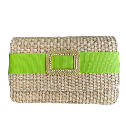 Woven clutch with a green strap on a wooden surface