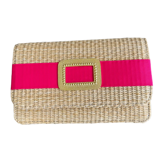 Woven clutch with a pink strap and gold buckle on a wooden surface