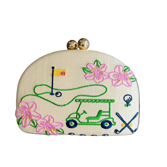 Embroidered golf-themed pouch with flowers on a wooden surface