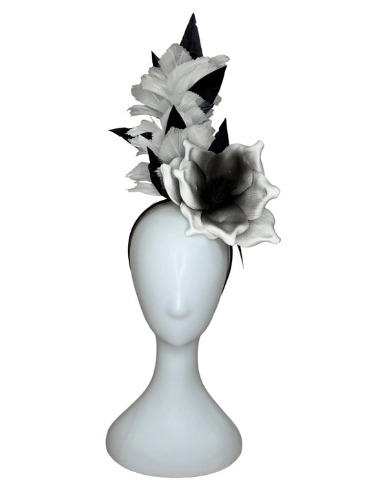 White flower hair clip on a mannequin head against a beige background