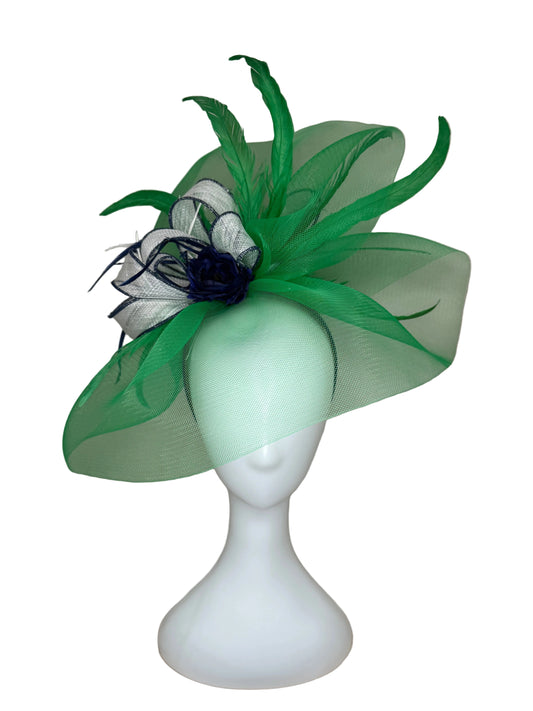Green and white decorative headpiece on a mannequin head against a beige background