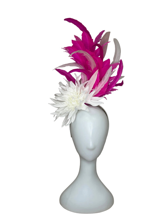White vase with pink and white feathers on a beige background