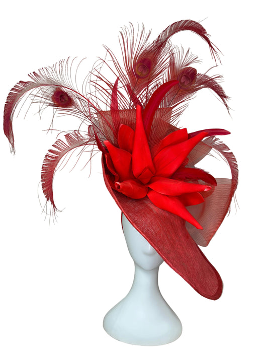 Red feathered headpiece on a mannequin head against a beige fabric background